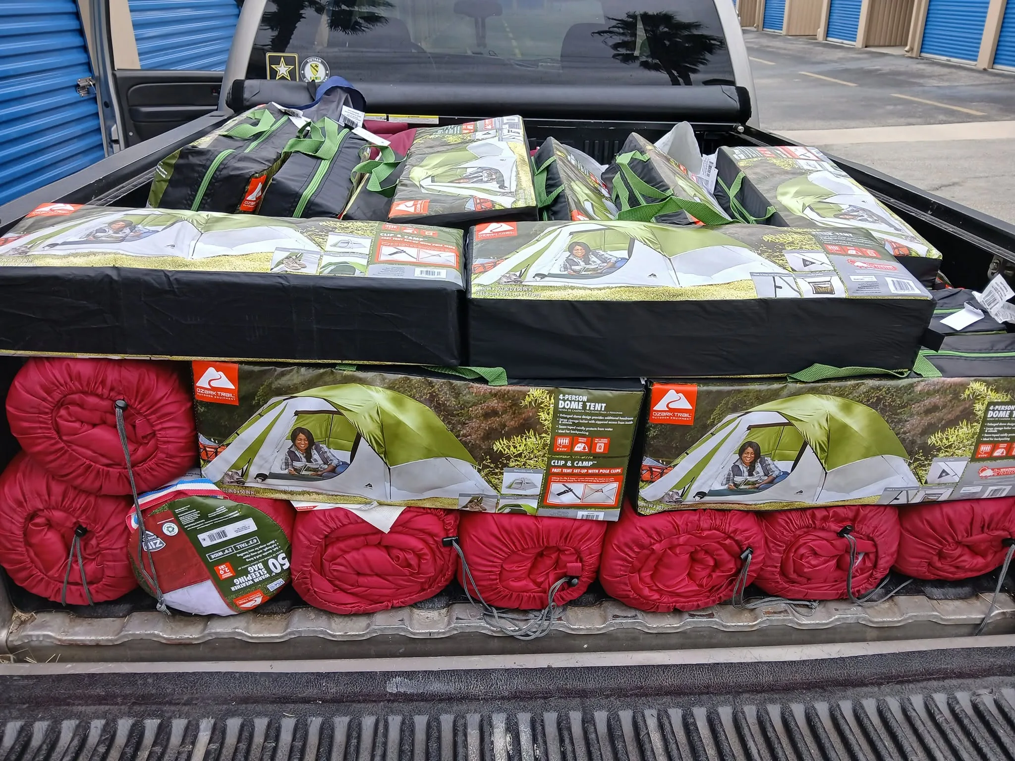 A truck bed loaded with tents and sleeping bags
